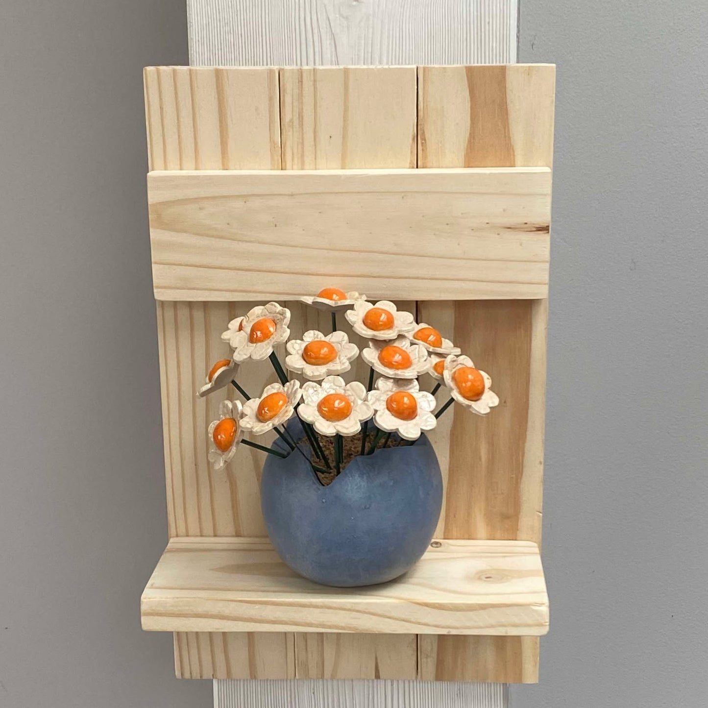 Petites fleurs blanches sur étagère en pin