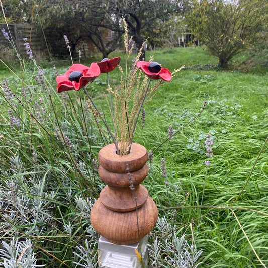 Trois coquelicots dans leur vase en bois